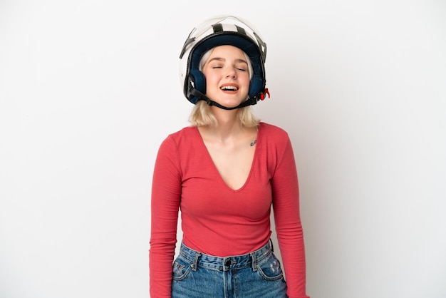 Giovane donna caucasica con un casco da motociclista isolato su sfondo bianco che ride