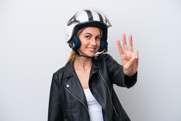 Giovane donna caucasica con un casco da motociclista isolato su sfondo bianco felice e contando tre con le dita