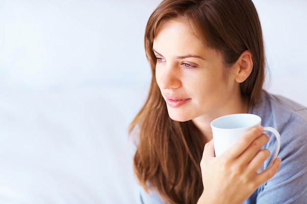 Giovane donna caucasica con un pensiero sul caffè Ritratto di una giovane donna carina persa in pensieri profondi con una tazza di caffè
