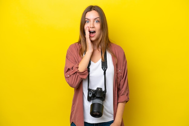 Giovane donna caucasica del fotografo isolata su sfondo giallo con espressione facciale sorpresa e scioccata