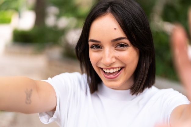 Giovane donna caucasica felice all'aperto facendo un selfie