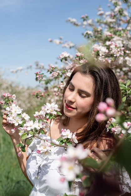 Giovane donna caucasica godendo la fioritura di un melo