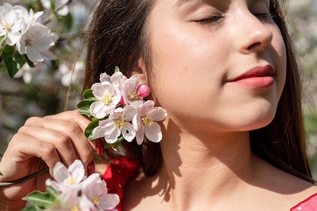 Giovane donna caucasica godendo la fioritura di un melo