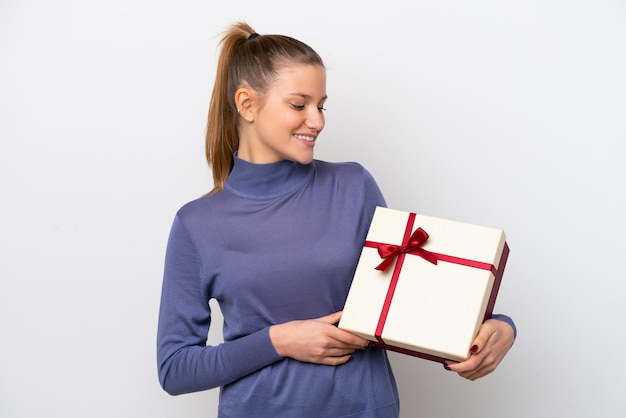 Giovane donna caucasica in possesso di un regalo isolato su sfondo bianco con felice espressione