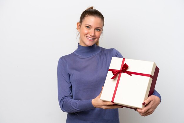 Giovane donna caucasica in possesso di un regalo isolato su sfondo bianco con felice espressione