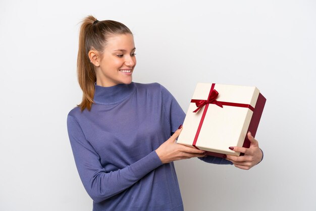 Giovane donna caucasica in possesso di un regalo isolato su sfondo bianco con felice espressione