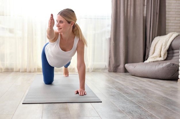 Giovane donna caucasica incinta che prepara yoga a casa