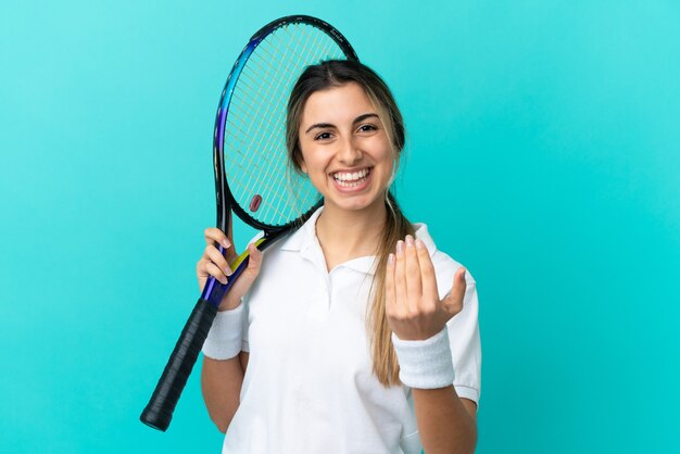 Giovane donna caucasica isolata giocando a tennis e facendo un gesto imminente coming