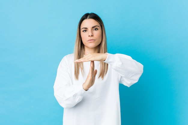 Giovane donna caucasica isolata mostrando un gesto di timeout.