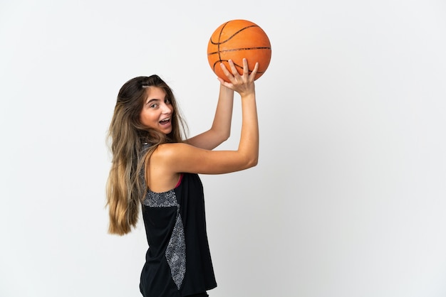Giovane donna caucasica isolata su bianco giocando a basket