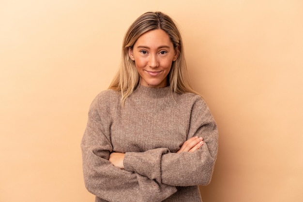 Giovane donna caucasica isolata su fondo beige felice, sorridente e allegra.