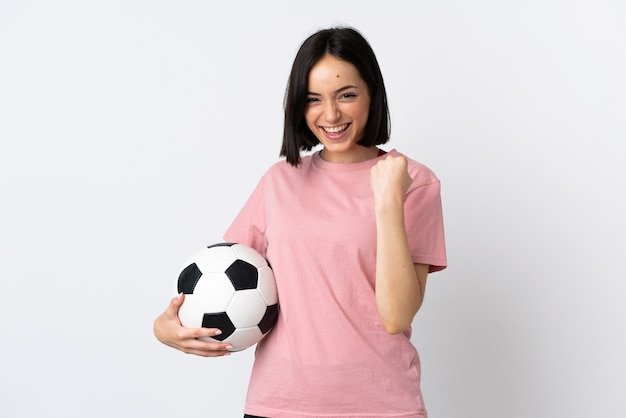 Giovane donna caucasica isolata su priorità bassa bianca con il pallone da calcio che celebra una vittoria