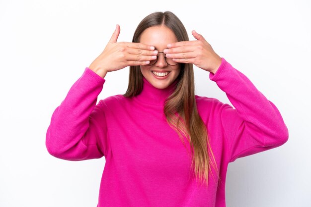 Giovane donna caucasica isolata su sfondo bianco che copre gli occhi con le mani e sorride