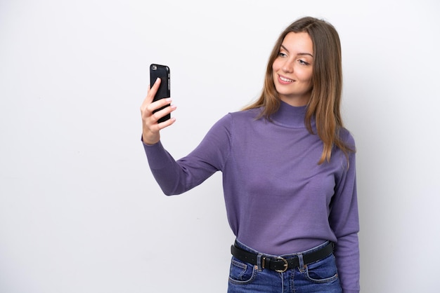 Giovane donna caucasica isolata su sfondo bianco che fa un selfie