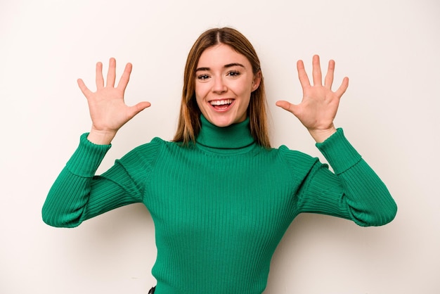 Giovane donna caucasica isolata su sfondo bianco che mostra il numero dieci con le mani