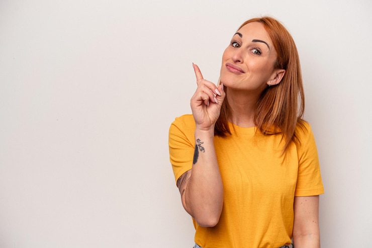 Foto giovane donna caucasica isolata su sfondo bianco che mostra il numero uno con il dito.