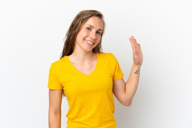 Giovane donna caucasica isolata su sfondo bianco che saluta con la mano con l'espressione felice