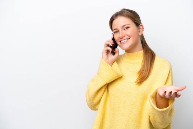 Giovane donna caucasica isolata su sfondo bianco che tiene una conversazione con il telefono cellulare con qualcuno