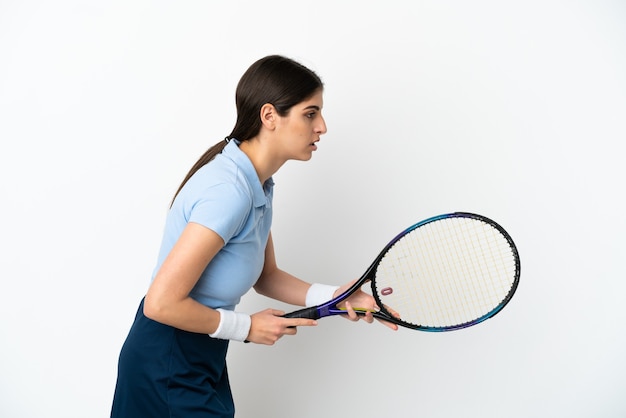 Giovane donna caucasica isolata su sfondo bianco giocando a tennis