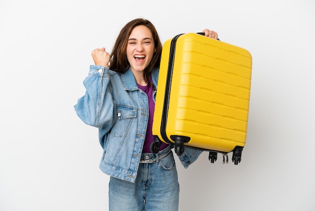 Giovane donna caucasica isolata su sfondo bianco in vacanza con valigia da viaggio