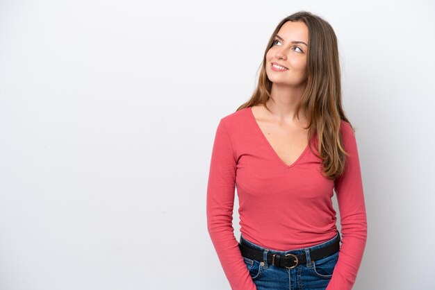 Giovane donna caucasica isolata su sfondo bianco pensando a un'idea mentre guarda in alto