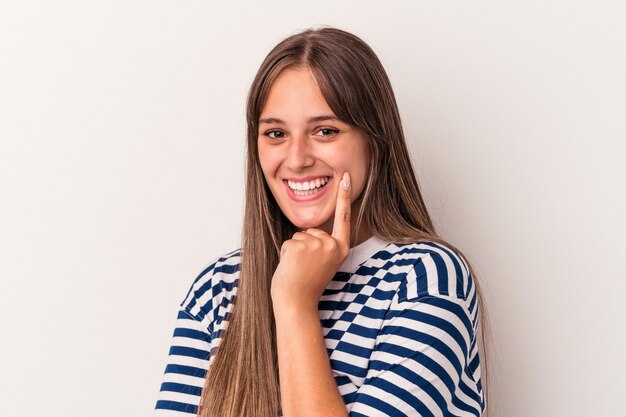 Giovane donna caucasica isolata su sfondo bianco sorridente felice e fiducioso, toccando il mento con la mano.