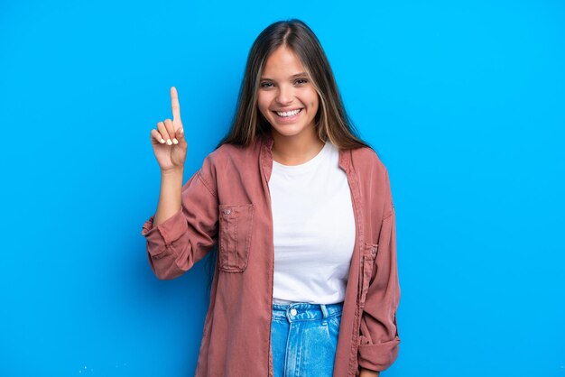 Giovane donna caucasica isolata su sfondo blu che indica una grande idea