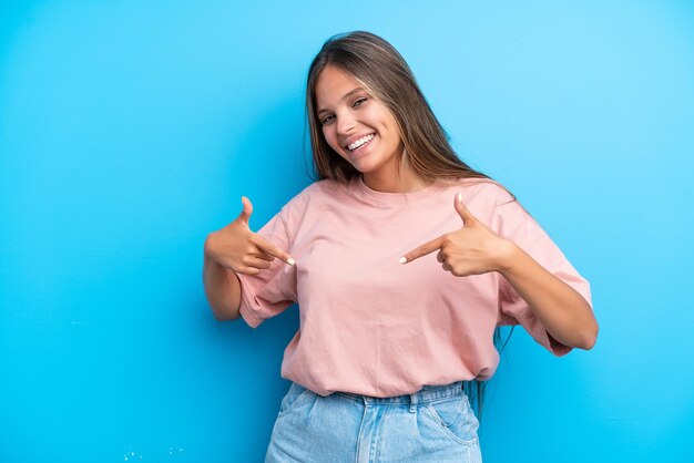 Giovane donna caucasica isolata su sfondo blu orgogliosa e soddisfatta