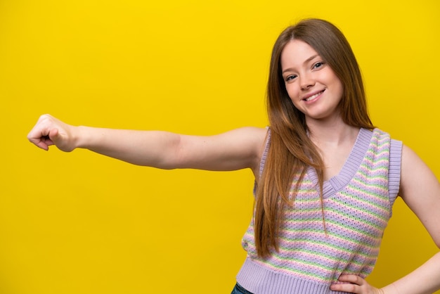Giovane donna caucasica isolata su sfondo giallo che dà un pollice in alto gesto