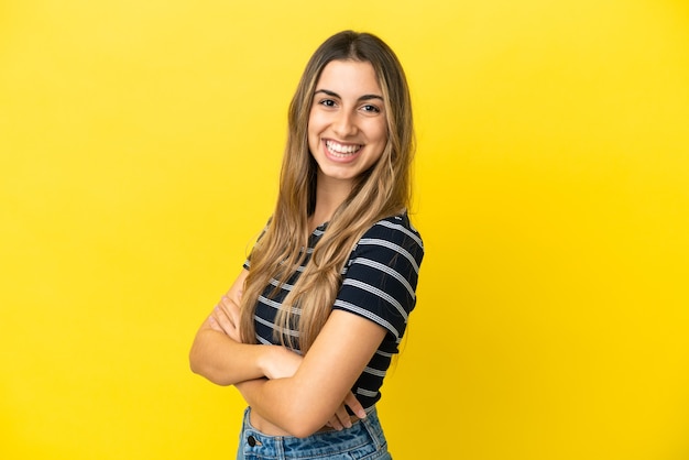 Giovane donna caucasica isolata su sfondo giallo guardando di lato e sorridente