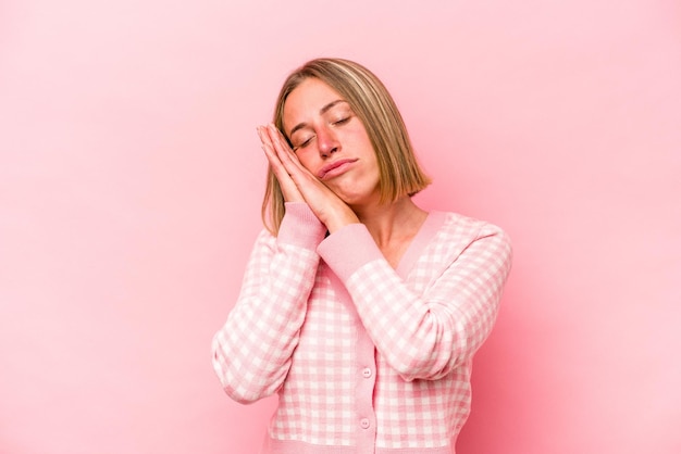 Giovane donna caucasica isolata su sfondo rosa che sbadiglia mostrando un gesto stanco che copre la bocca con la mano