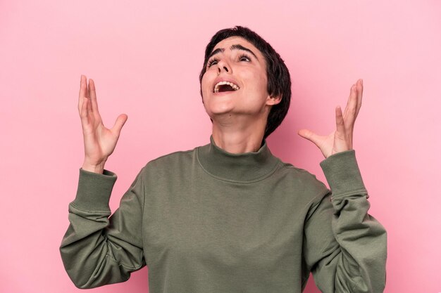 Giovane donna caucasica isolata su sfondo rosa che urla al cielo guardando frustrata