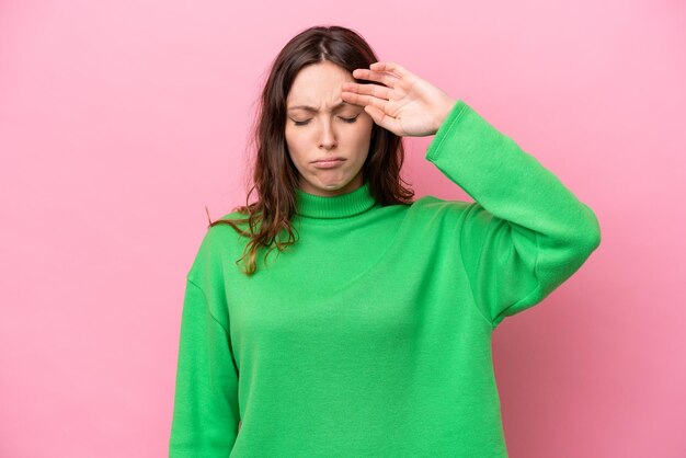 Giovane donna caucasica isolata su sfondo rosa con espressione stanca e malata