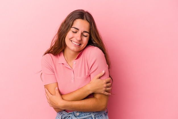 Giovane donna caucasica isolata su sfondo rosa ridendo e divertendosi.