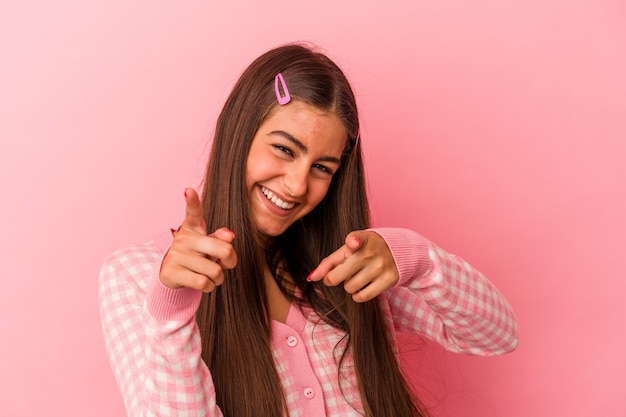 Giovane donna caucasica isolata su sfondo rosa sorrisi allegri che puntano alla parte anteriore.