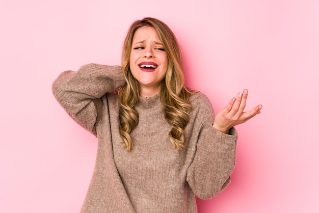 Giovane donna caucasica isolata sul colore rosa che grida di rabbia.