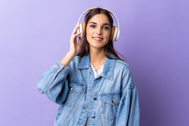 Giovane donna caucasica isolata sulla musica d'ascolto viola