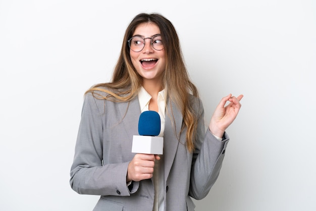 Giovane donna caucasica presentatrice televisiva isolata su sfondo bianco con l'intenzione di realizzare la soluzione sollevando un dito
