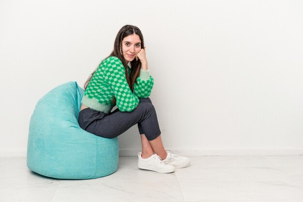 Giovane donna caucasica seduta su un soffio isolato su sfondo bianco