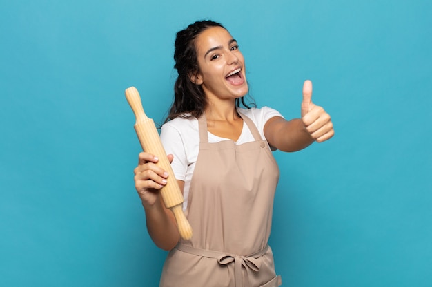 Giovane donna caucasica sentirsi orgogliosa, spensierata, sicura e felice, sorridendo positivamente con i pollici in su