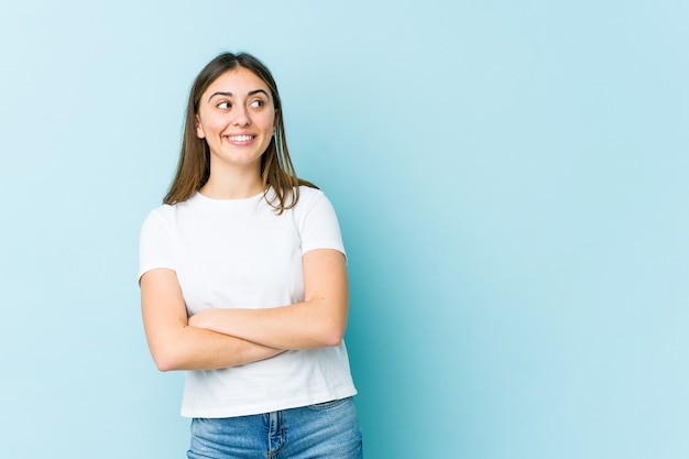 Giovane donna caucasica sorridente fiducioso con le braccia incrociate.