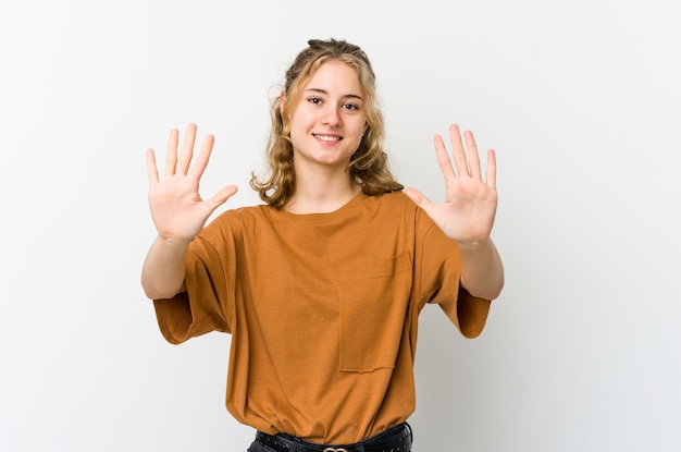 Giovane donna caucasica su backrgound bianco che mostra il numero dieci con le mani.