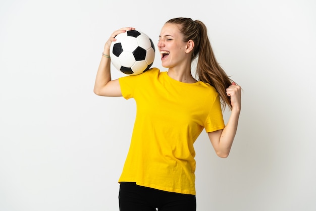 Giovane donna caucasica su bianco con pallone da calcio che celebra una vittoria