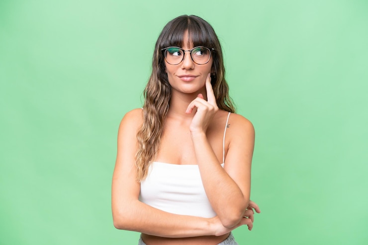 Foto giovane donna caucasica su uno sfondo isolato che pensa a un'idea mentre guarda in alto