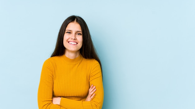 Giovane donna caucasica sulla parete blu, ridere e divertirsi.