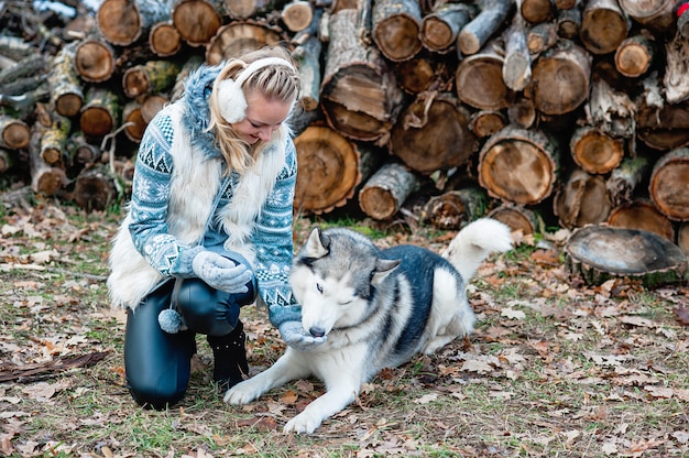 Giovane donna che abbraccia il suo cane husky