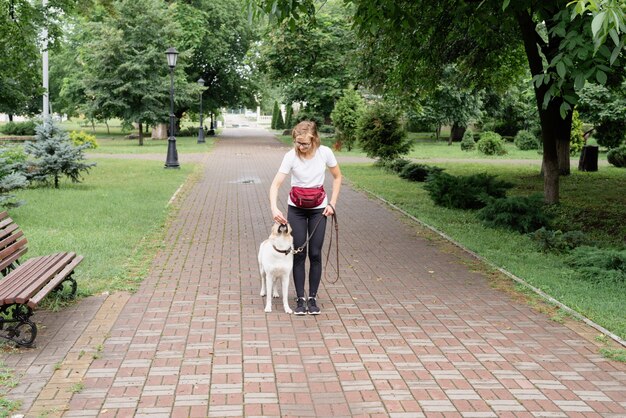 Giovane donna che addestra il suo cane in un parco