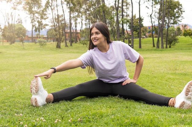 Giovane donna che allunga le gambe nel parco