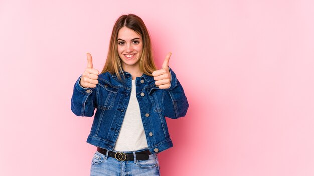 Giovane donna che alza i pollici in su