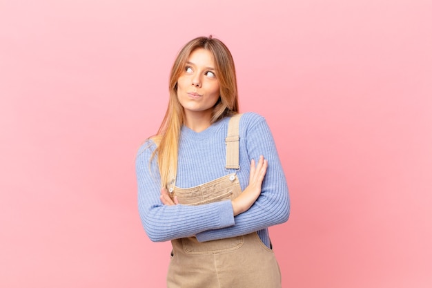 Giovane donna che alza le spalle, si sente confusa e incerta